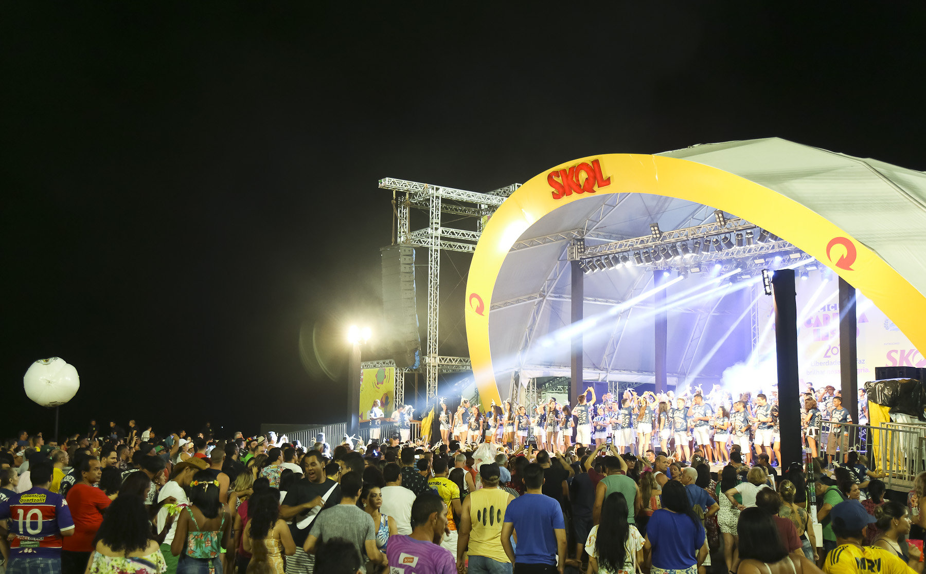 Foto mostra um grupo de pessoas em frente ao palco do pré-carnaval no aterro da praia de iracema